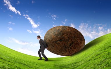 Businessman rolling a giant stone clipart