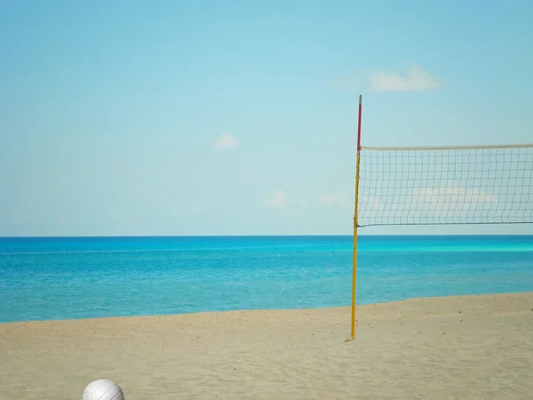 Пляжная волейбольная сетка и мяч на пляже возле Карибского океана — стоковое фото