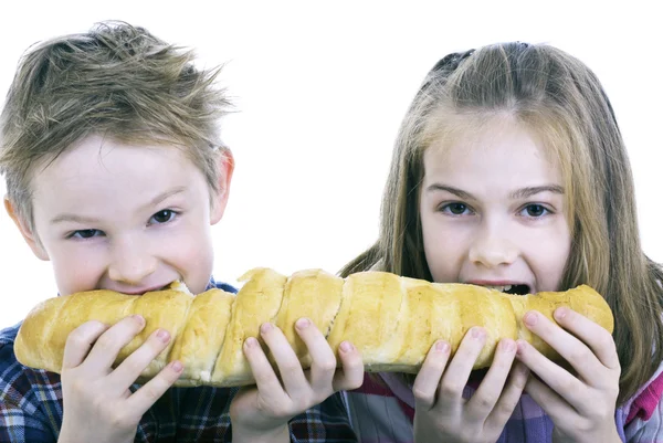 Detailní záběr na dvě děti jíst chléb — Stock fotografie