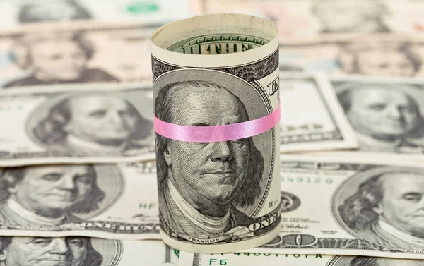 100 US dollar wrapped by ribbon on money background — Stock Photo, Image