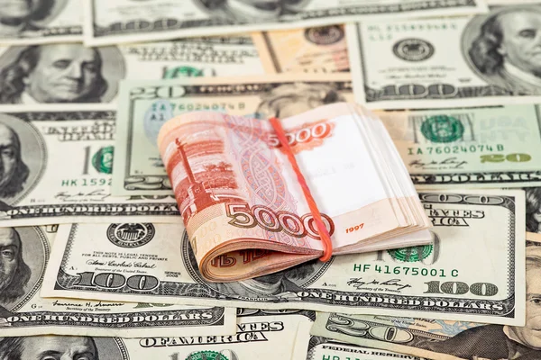 Складные пятитысячные рубли на долларовом фоне — стоковое фото