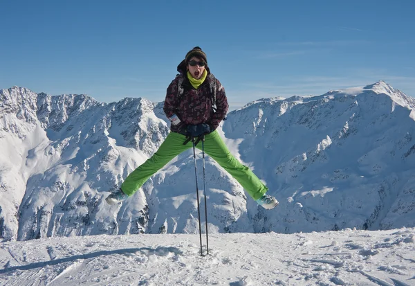 Γυναίκα σε υφάσματα σκι άλμα πάνω από τα χιονισμένα βουνά, Αυστρία — Φωτογραφία Αρχείου