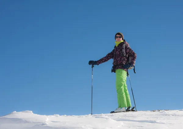 Ένα κορίτσι σε ένα κοστούμι σκι ενάντια στον ουρανό — Φωτογραφία Αρχείου