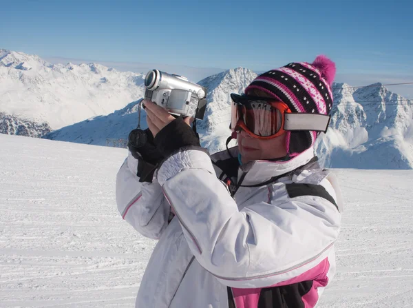 Skidåkare i snöiga berg med en kamera — Stockfoto