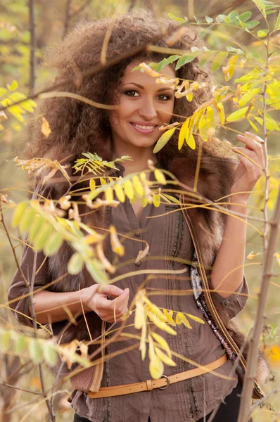 Woman standing among the branches of bushes — Stock Photo, Image