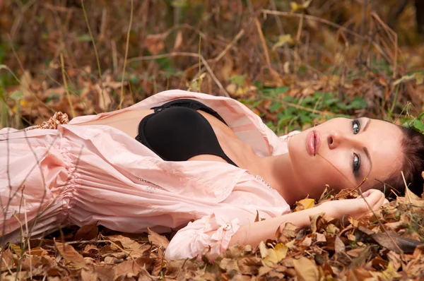Frau liegt auf den Blättern — Stockfoto