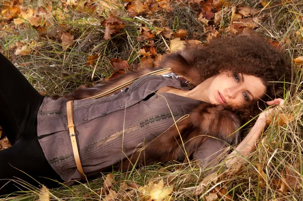 Mulher deitada nas folhas — Fotografia de Stock