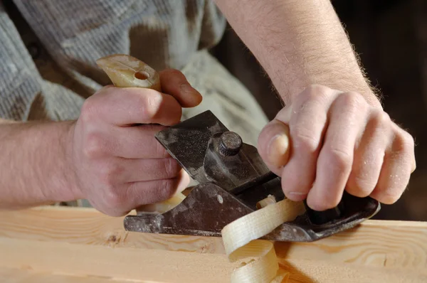 Carpintero trabajando con una cepilladora en su taller — Foto de Stock