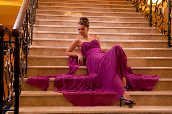 Donna in un abito lungo sdraiata sulle scale — Foto Stock
