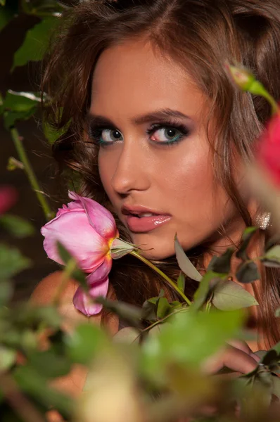 Kvinna som står bland rosenbuskar — Stockfoto