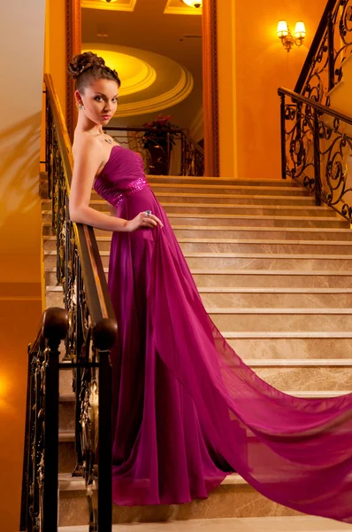 Femme dans une belle robe fente sur les escaliers — Photo