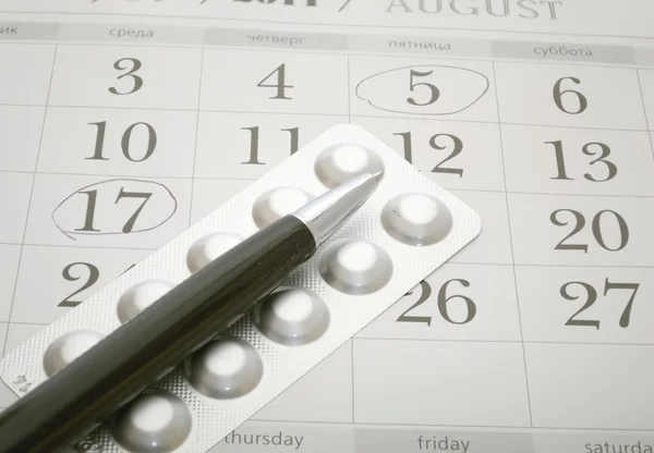 Píldoras anticonceptivas y pluma de primer plano — Foto de Stock