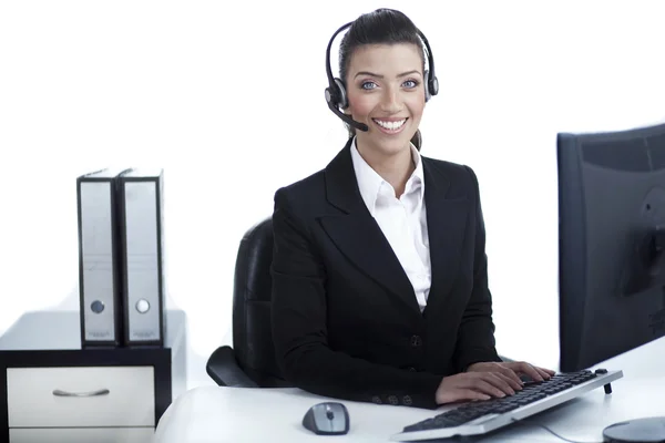 Mulher de negócios bonita trabalhando no escritório usando fone de ouvido — Fotografia de Stock