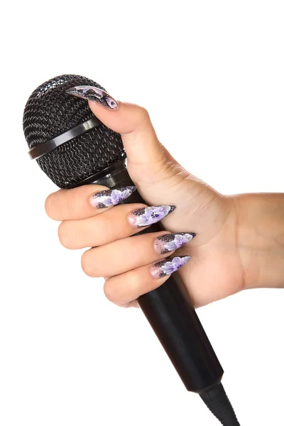 Kvinnlig hand med manikyr innehar mikrofon isolerade — Stockfoto