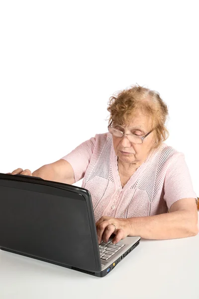 The old woman in glasses looks at the screen notebook isolated — Stock Photo, Image