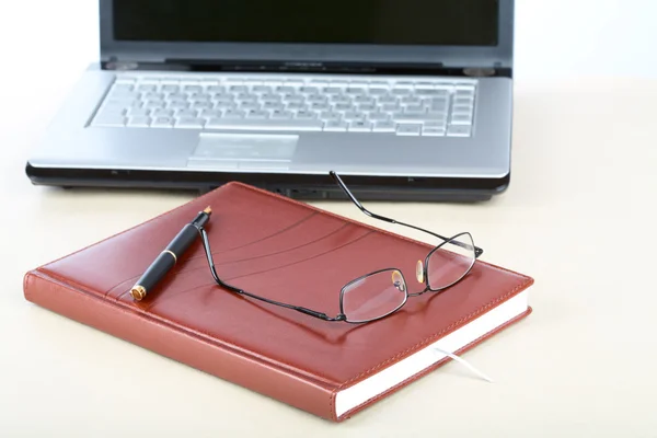 Organizador, gafas, bolígrafo y cuaderno en un escritorio — Foto de Stock