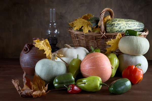 Geerntete Kürbisse mit Herbstlaub auf dem Teller — Stockfoto
