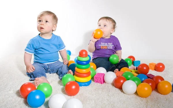 Bebês brincam com brinquedos — Fotografia de Stock