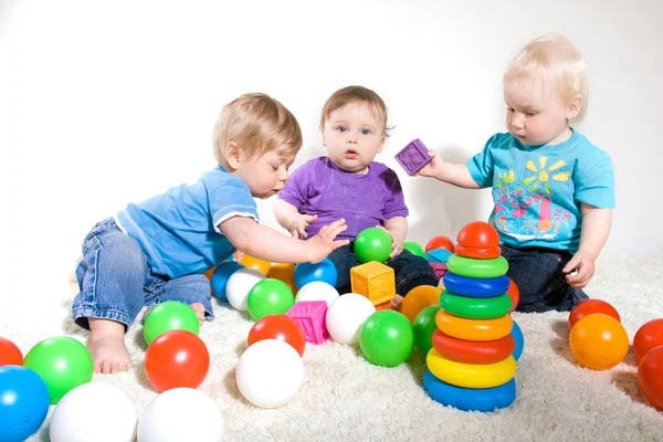 Bebês brincam com brinquedos — Fotografia de Stock