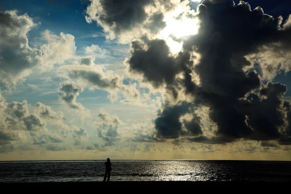 Güneşin doğuşunda sahilde duran siluet — Stok fotoğraf