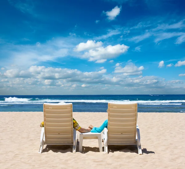 Para w fotelach plażowych trzymająca się za ręce w pobliżu oceanu — Zdjęcie stockowe