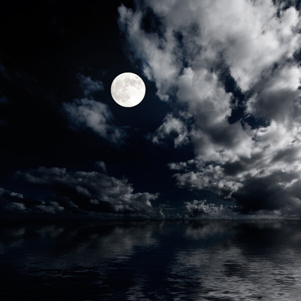Moon and clouds above sea at night photo