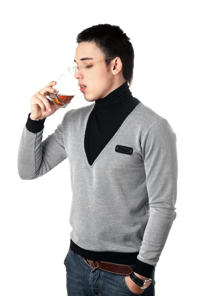 Молодий чоловік п'є віскі зі склянки — стокове фото