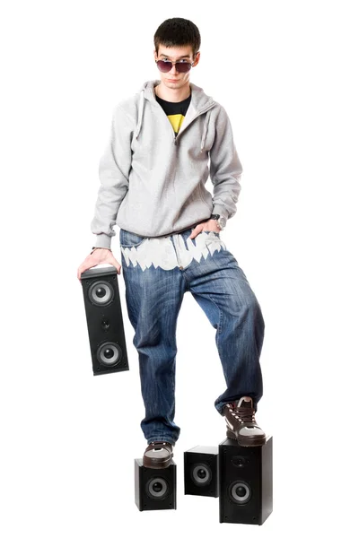 Young man in sunglasses standing on the speakers — Stock Photo, Image