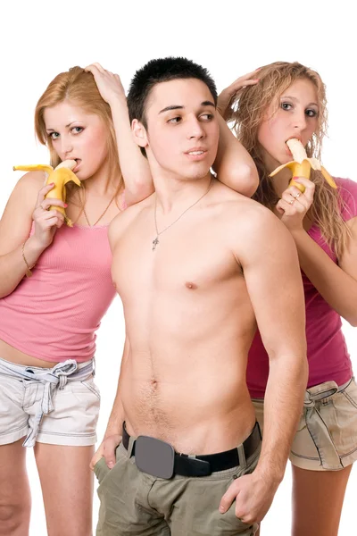 Молодий чоловік і дві красиві жінки з бананами — стокове фото