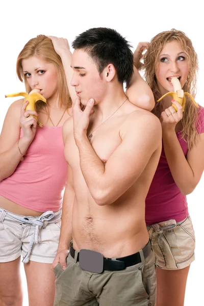 Молодий чоловік і дві грайливі жінки з бананами — стокове фото
