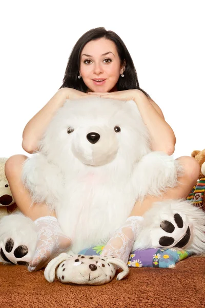 Girl sitting in an embrace with a large teddy bear — Stock Photo, Image