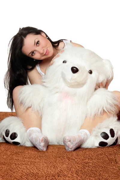 Schönes Mädchen sitzt in einer Umarmung mit einem Teddybär — Stockfoto