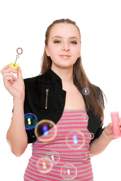 Портрет улыбающейся молодой женщины надувает пузыри — стоковое фото