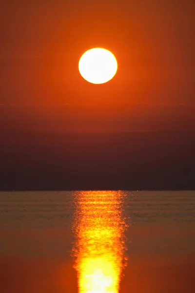 Puesta de sol roja sobre una superficie marina —  Fotos de Stock