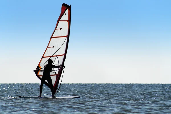 Silhueta de um windsurfista no mar azul — Fotografia de Stock
