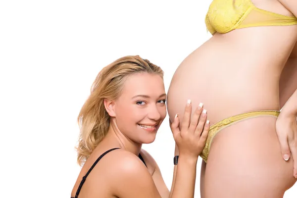 Femme souriante et le ventre de la petite amie enceinte — Photo