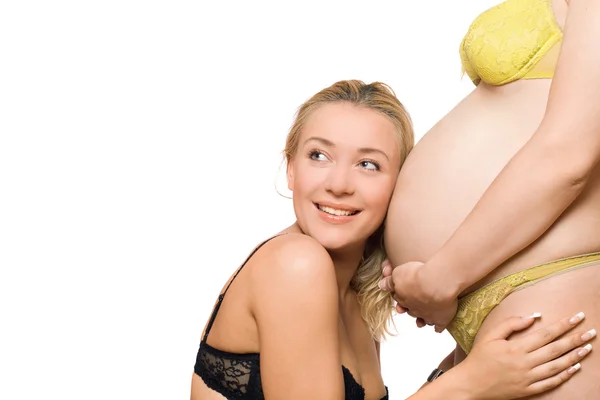 幸せな若い女性と妊娠中のガール フレンドの腹 — ストック写真