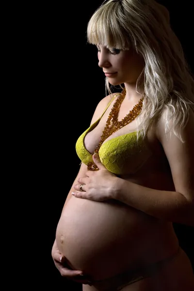 Беременная молодая женщина в жёлтом белье. Isolated — стоковое фото
