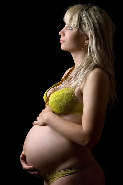 Fille enceinte en lingerie jaune. Isolé — Photo