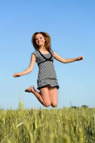 필드에 점프 하는 매력적인 여자 — 스톡 사진