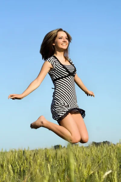 Mooi meisje springen in veld — Stockfoto