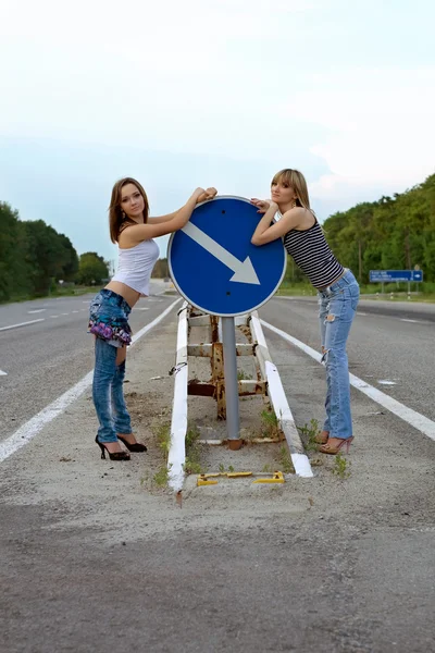 Twee mooie meisjes staan op een weg — Stockfoto
