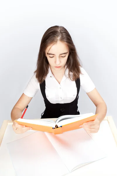 Schoolgirl reads the book — Stock Photo, Image