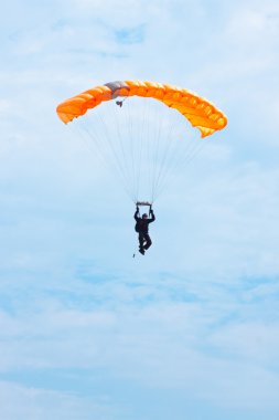 Parachutist in the blue sky clipart