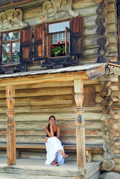 Fiatal nő régi orosz fából készült ház előtt — Stock Fotó