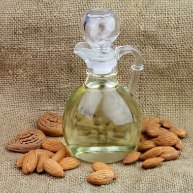 A bottle of almond oil with nuts clipart