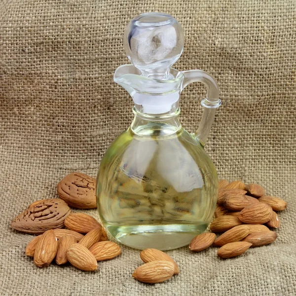 A bottle of almond oil with nuts — Stock Photo, Image
