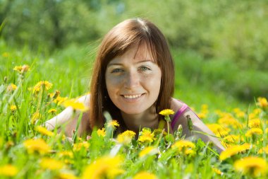 Freckle woman relaxing in dandelion clipart