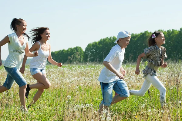 快乐的妇女有个十几岁在草中运行 — 图库照片