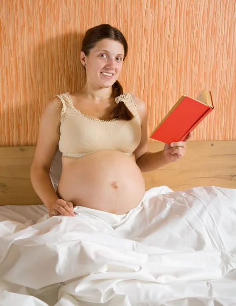 Těhotná žena čtení kniha — Stock fotografie